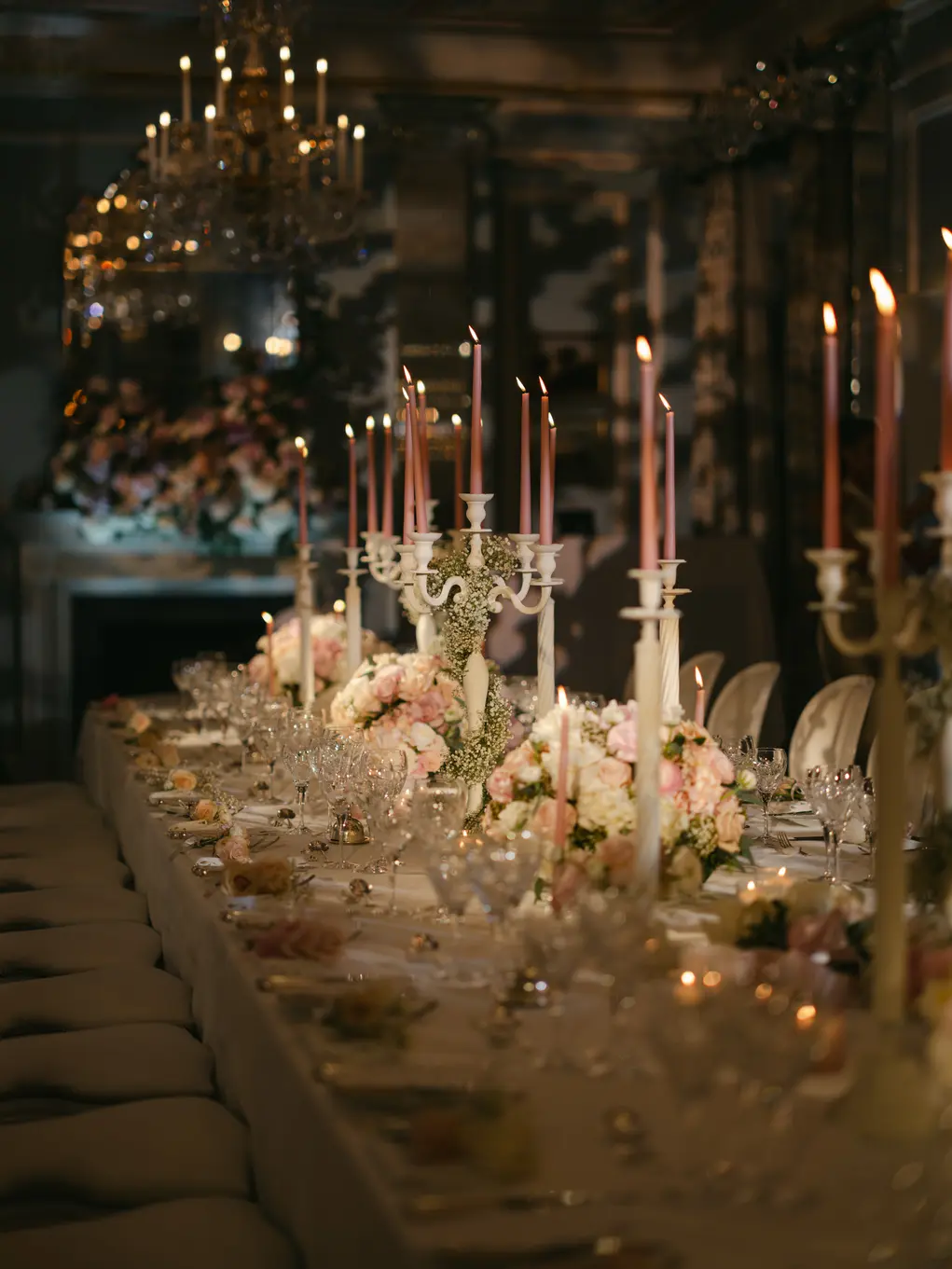 A dining table with candles, flowers and a white tablecloth