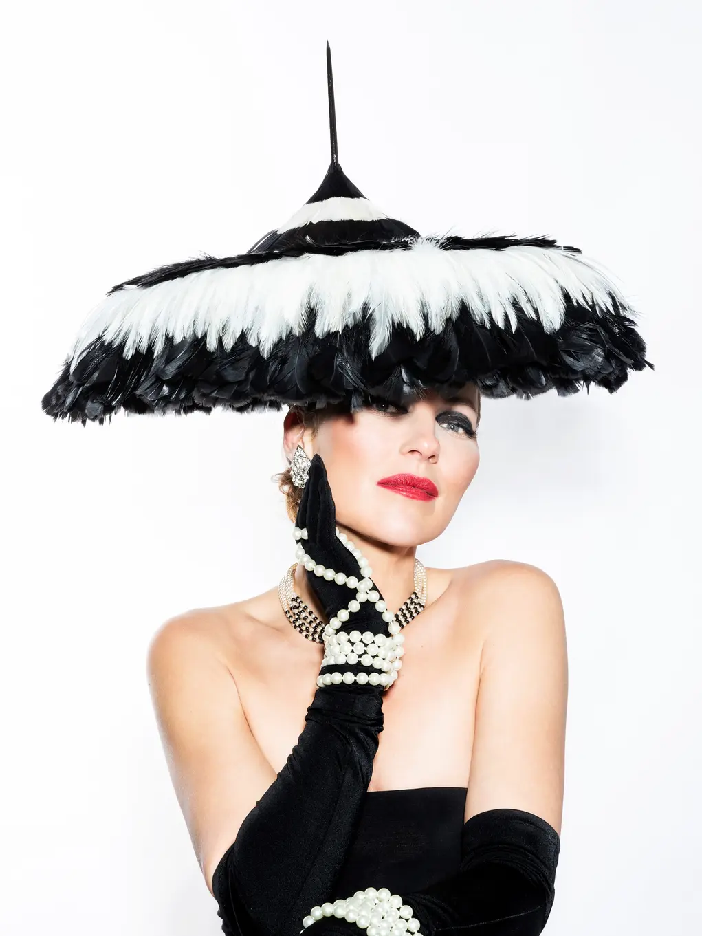 A woman wears a black and white hat that looks like an umbrella