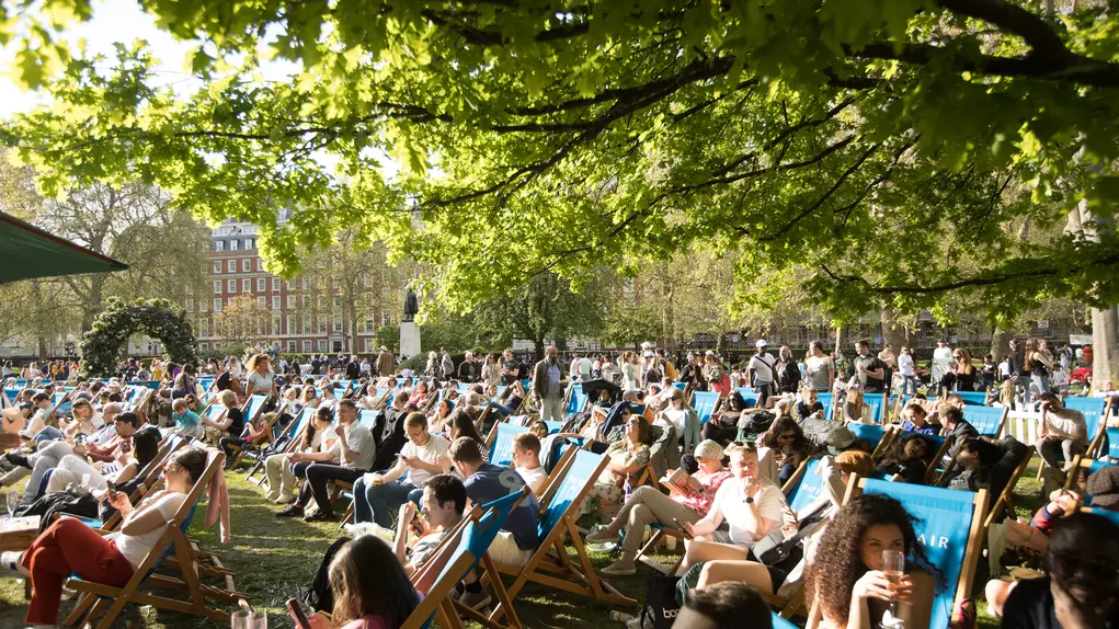 A park filled with hundreds of people sitting on deckchairs