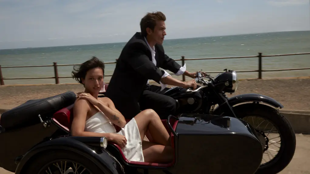 A married couple on a motorbike with a sidecar