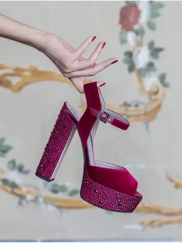 Hand holding pink platform shoe